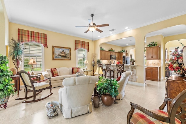 living area with arched walkways, ceiling fan, ornamental molding, and visible vents