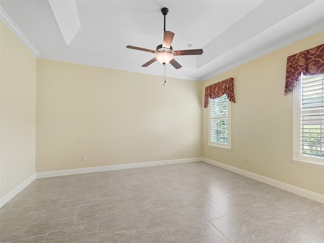 unfurnished room with baseboards, a ceiling fan, crown molding, and a raised ceiling