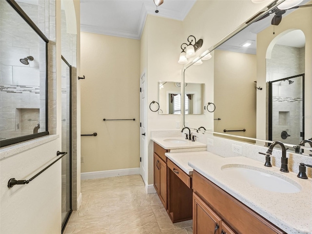 full bath featuring a stall shower, double vanity, a sink, and ornamental molding