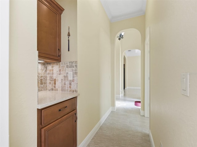 corridor with arched walkways and ornamental molding