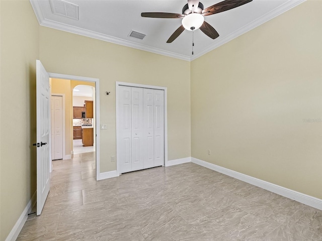 unfurnished bedroom with crown molding, visible vents, and arched walkways
