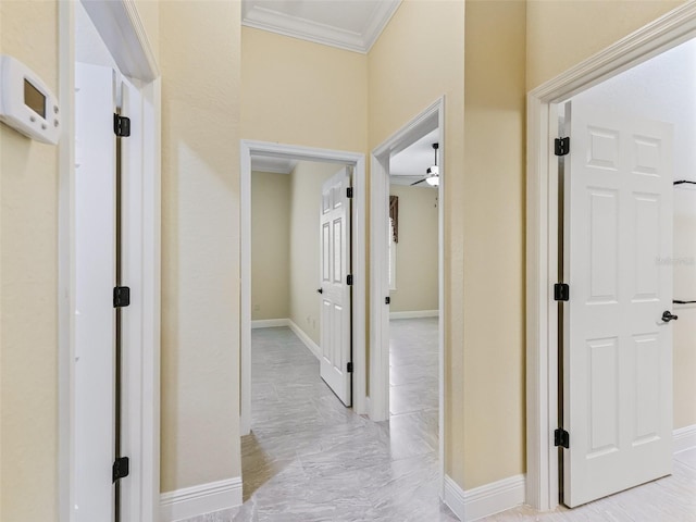 hall with crown molding, marble finish floor, and baseboards