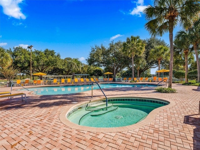 community pool featuring a patio, a community hot tub, and fence