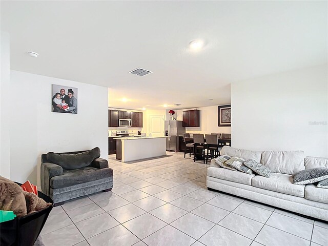 living area featuring light tile patterned floors and visible vents