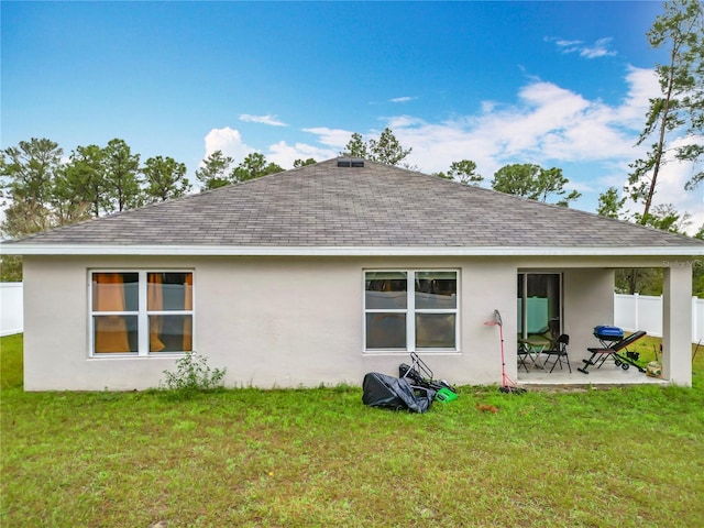 back of property featuring a patio area, roof with shingles, a yard, and fence