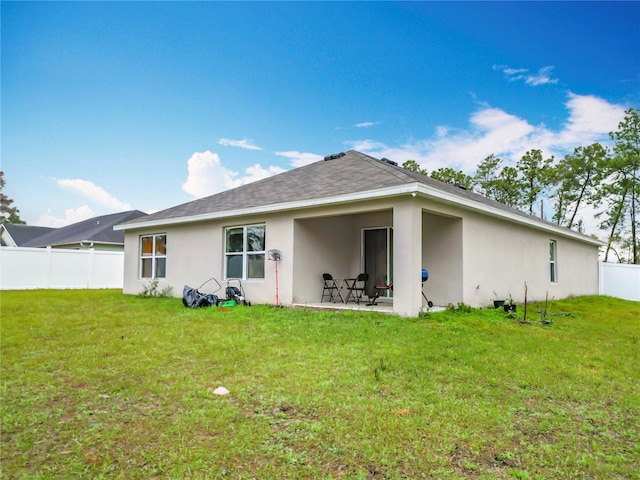 back of house with a patio area, a yard, fence, and stucco siding