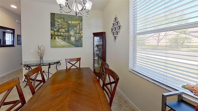 dining area with a chandelier, carpet flooring, and baseboards