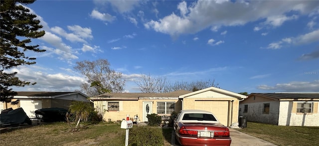 ranch-style house with a front yard, a garage, and driveway