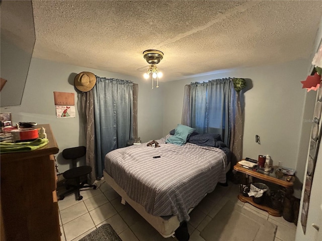 bedroom featuring light tile patterned floors and a textured ceiling