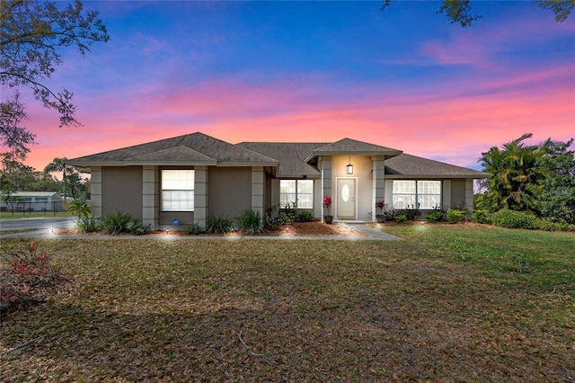 view of front facade with stucco siding and a front lawn