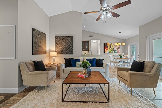 living area featuring visible vents, baseboards, high vaulted ceiling, and ceiling fan with notable chandelier