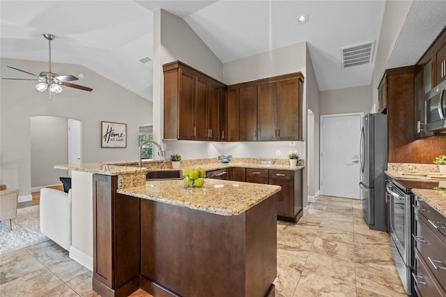 kitchen featuring arched walkways, visible vents, stainless steel appliances, and lofted ceiling