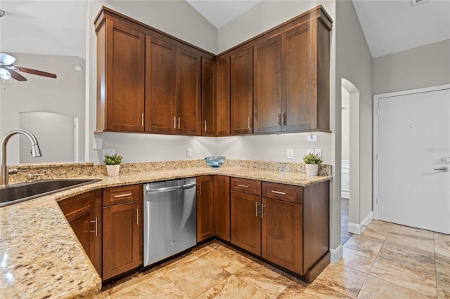 kitchen featuring a sink, light stone counters, arched walkways, dishwasher, and ceiling fan