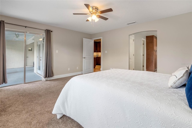 carpeted bedroom featuring access to exterior, visible vents, ceiling fan, baseboards, and arched walkways