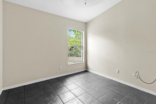 unfurnished room featuring baseboards and vaulted ceiling