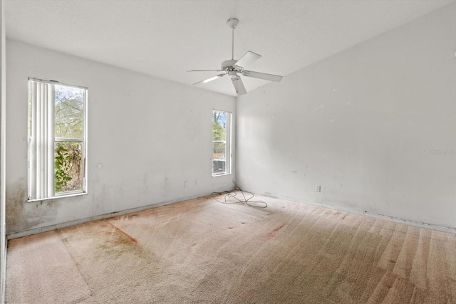 carpeted empty room with a ceiling fan