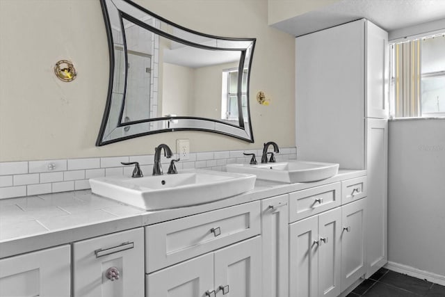 bathroom with tile patterned flooring, double vanity, a textured ceiling, and a sink