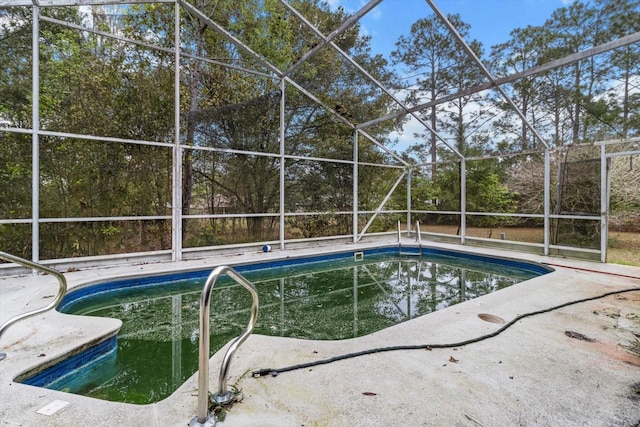 outdoor pool featuring glass enclosure and a patio