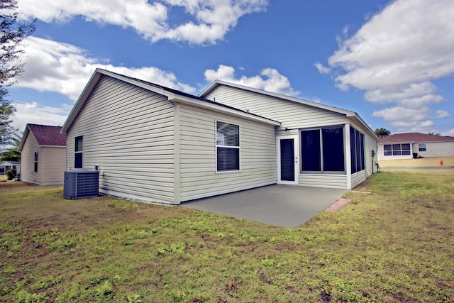 rear view of property with a patio, a lawn, and central AC