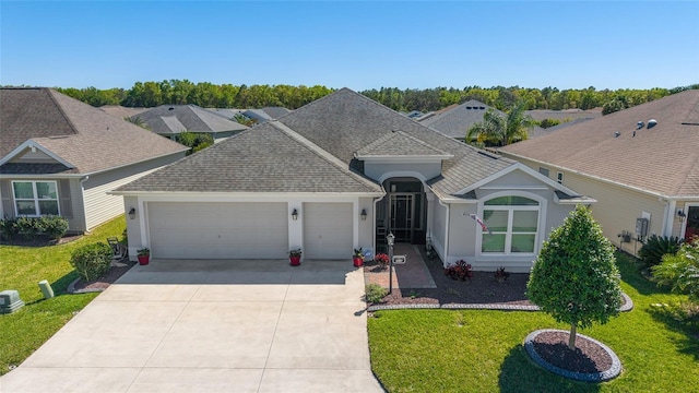 6083 Delphina Loop, The Villages, FL 32163 - view of front facade featuring stucco siding, driveway, a front lawn, roof with shingles, and an attached garage