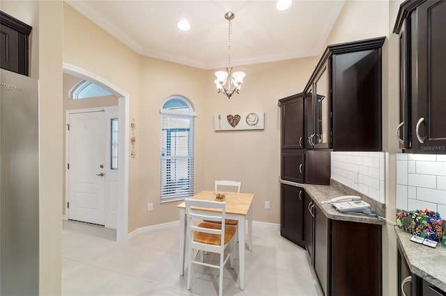 6083 Delphina Loop, The Villages, FL 32163 - kitchen with pendant lighting, ornamental molding, tasteful backsplash, dark brown cabinets, and a chandelier