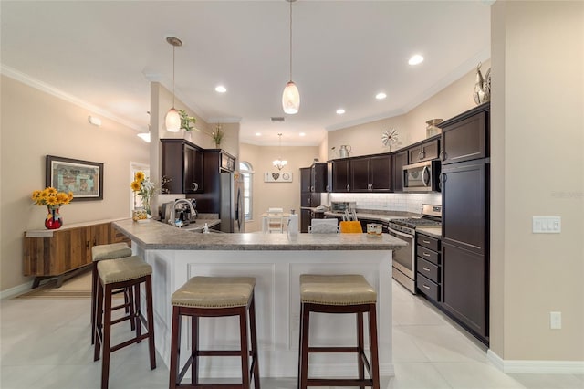 6083 Delphina Loop, The Villages, FL 32163 - kitchen with a sink, backsplash, appliances with stainless steel finishes, a breakfast bar area, and crown molding