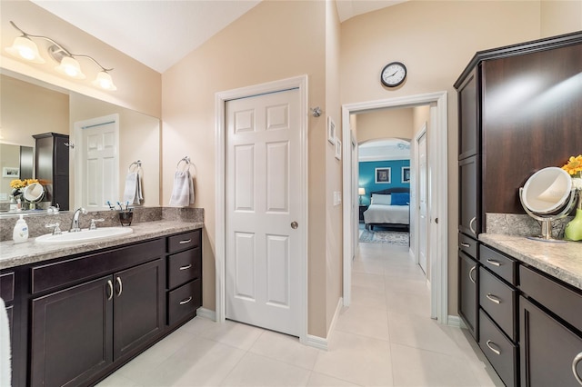 6083 Delphina Loop, The Villages, FL 32163 - ensuite bathroom with tile patterned floors, ensuite bathroom, baseboards, vanity, and vaulted ceiling