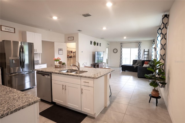 kitchen with visible vents, light stone countertops, appliances with stainless steel finishes, white cabinets, and a sink