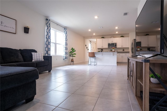 living area featuring recessed lighting, visible vents, baseboards, and light tile patterned floors