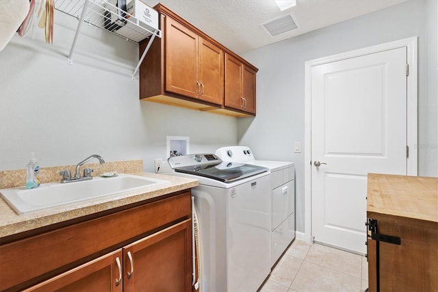2188 Gordon Path, The Villages, FL 32163 - laundry area with visible vents, washing machine and dryer, light tile patterned floors, cabinet space, and a sink