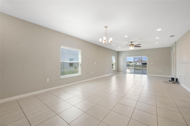 empty room featuring visible vents, ceiling fan with notable chandelier, recessed lighting, light tile patterned floors, and baseboards