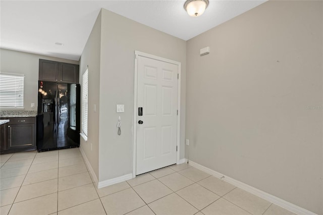 entrance foyer with light tile patterned floors and baseboards