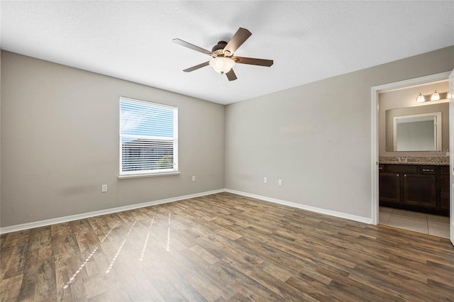 interior space featuring ceiling fan, baseboards, and wood finished floors