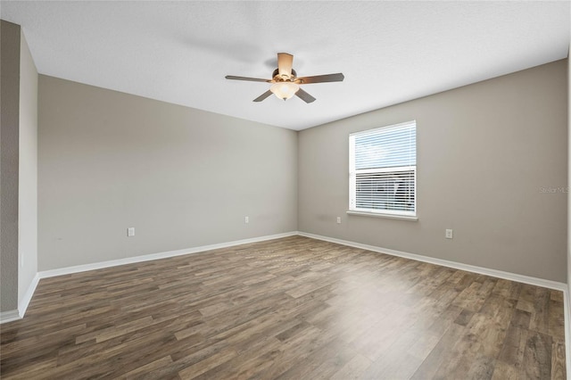 empty room featuring baseboards, wood finished floors, and a ceiling fan