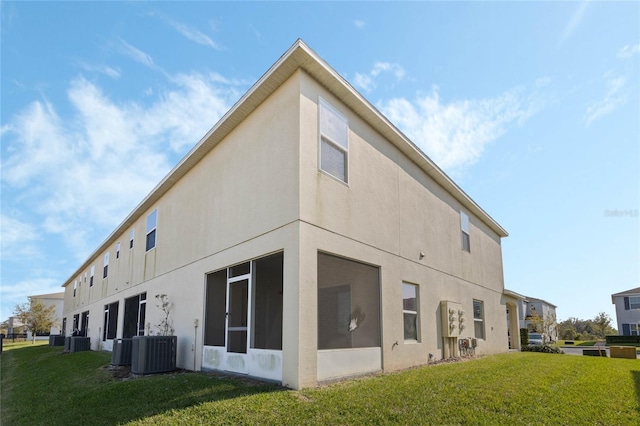 view of property exterior with a yard, central AC, and stucco siding