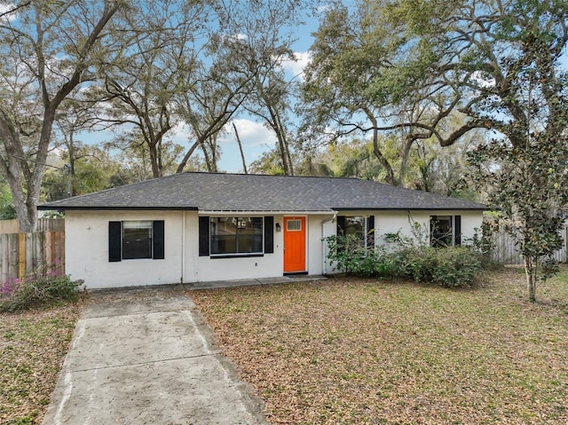 ranch-style home with stucco siding, a front yard, and fence