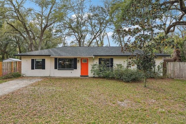 single story home featuring stucco siding, a front lawn, and fence