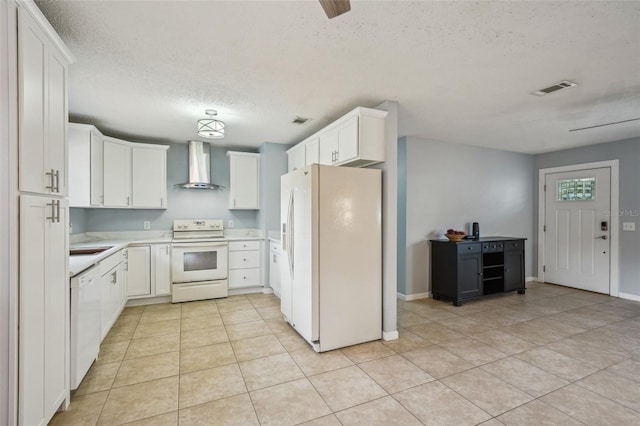 kitchen featuring visible vents, white appliances, light countertops, and wall chimney range hood