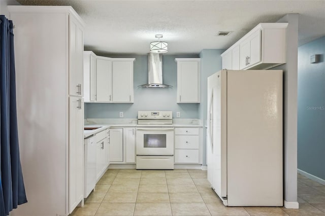 kitchen with white appliances, white cabinetry, and wall chimney range hood