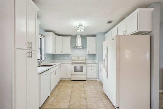 kitchen with visible vents, a sink, white appliances, wall chimney range hood, and light tile patterned floors