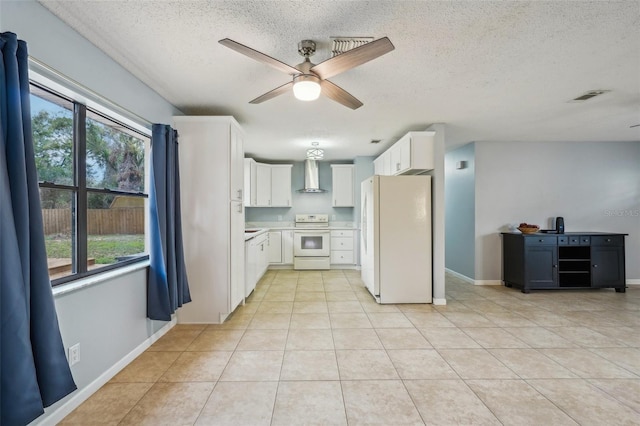 kitchen with light tile patterned floors, plenty of natural light, white appliances, and wall chimney exhaust hood