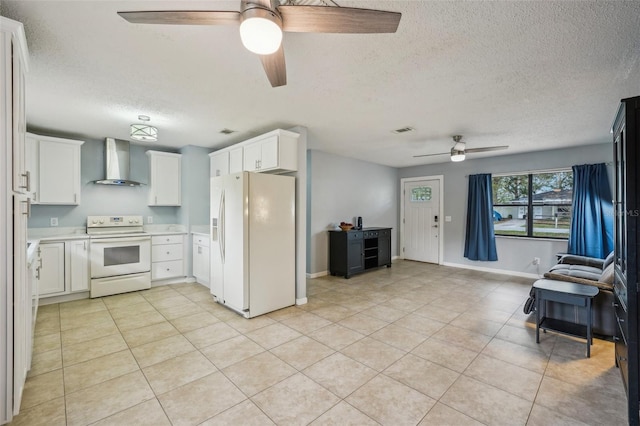 kitchen with white appliances, light tile patterned floors, light countertops, wall chimney exhaust hood, and open floor plan