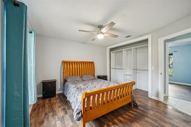 bedroom featuring wood finished floors, visible vents, a closet, and a textured ceiling