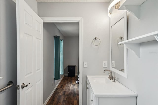 bathroom with baseboards, wood finished floors, and vanity