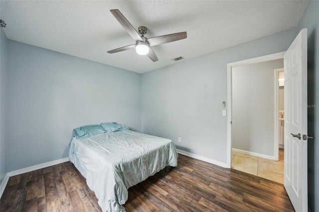 bedroom with visible vents, baseboards, and wood finished floors