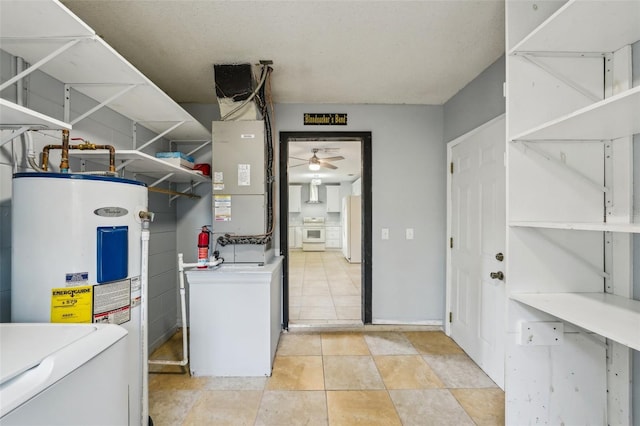 washroom featuring light tile patterned floors, electric water heater, ceiling fan, and laundry area