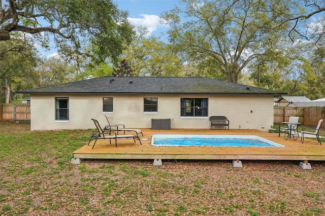 back of property featuring a wooden deck, a yard, and fence