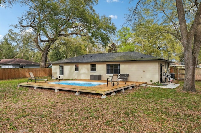 rear view of property with a deck, a fenced backyard, and a lawn