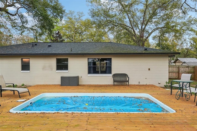 rear view of house with a deck and fence