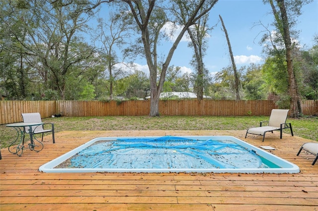 view of swimming pool featuring a deck and a fenced backyard